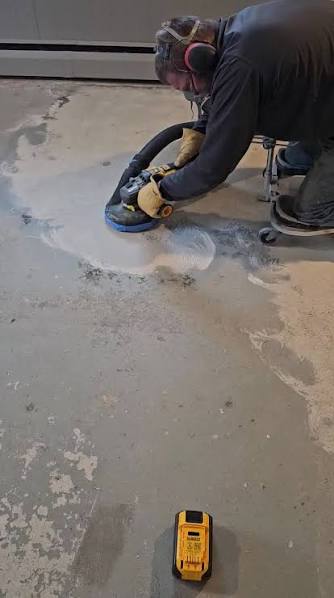 Diamond grinding a concrete floor edge during resin flooring preparation