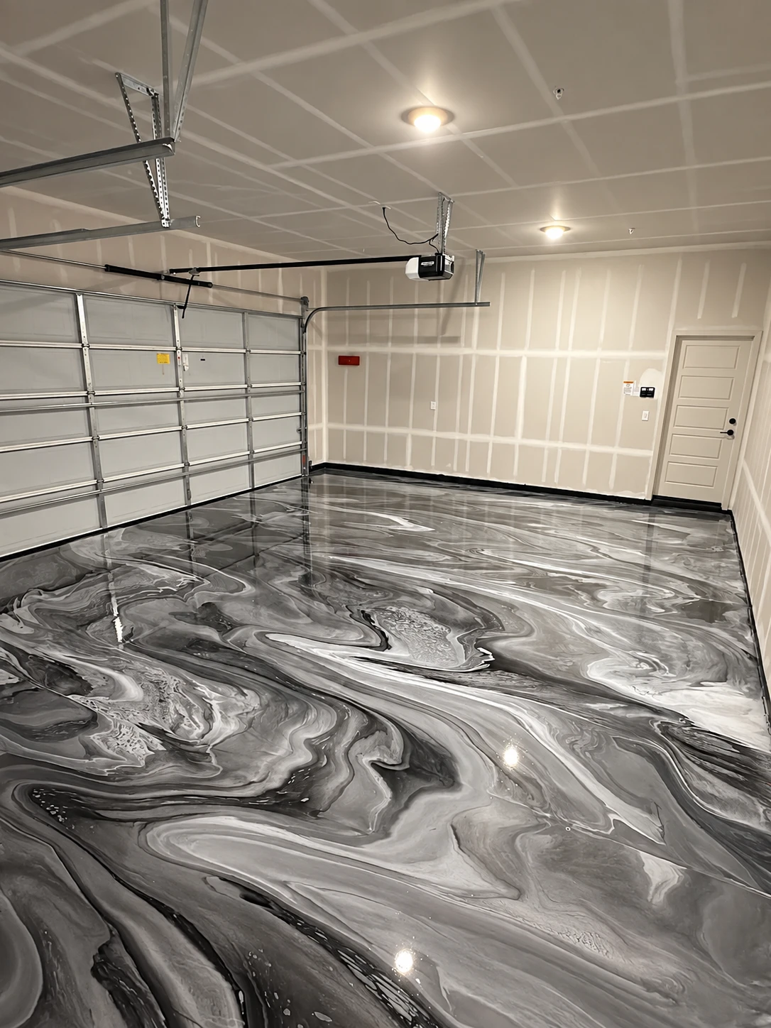 Metallic epoxy resin floor with a swirled, marbled grey and white finish