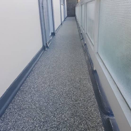 MMA resin flooring in a seamless commercial corridor with coved skirting